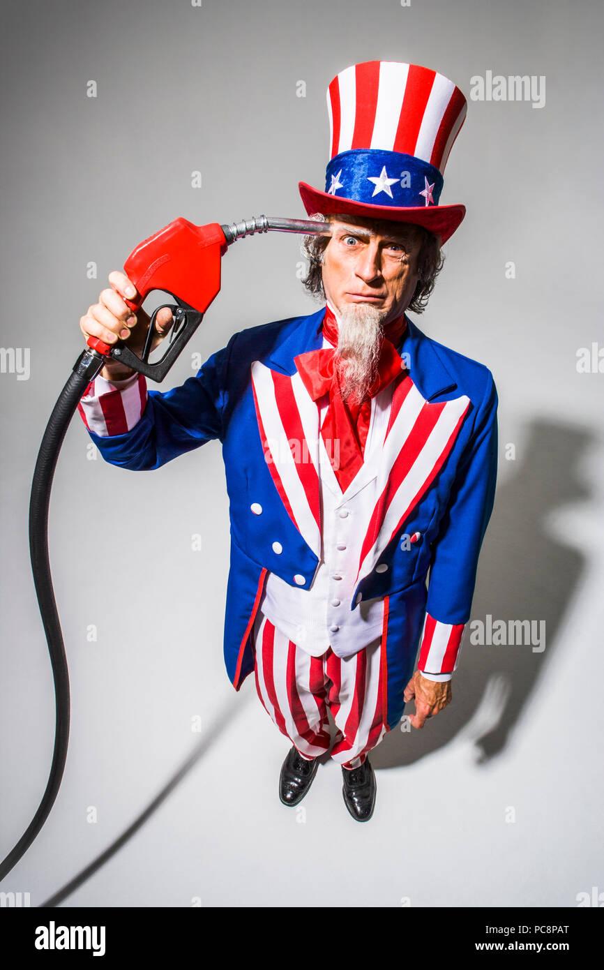 Uncle Sam stehend mit einer Gaspumpe nozzel vor ihm statt. Konzeptionelle Schuß mit der Darstellung der Amerikanischen Abhängigkeit vom Öl/Gas/Öl. Stockfoto