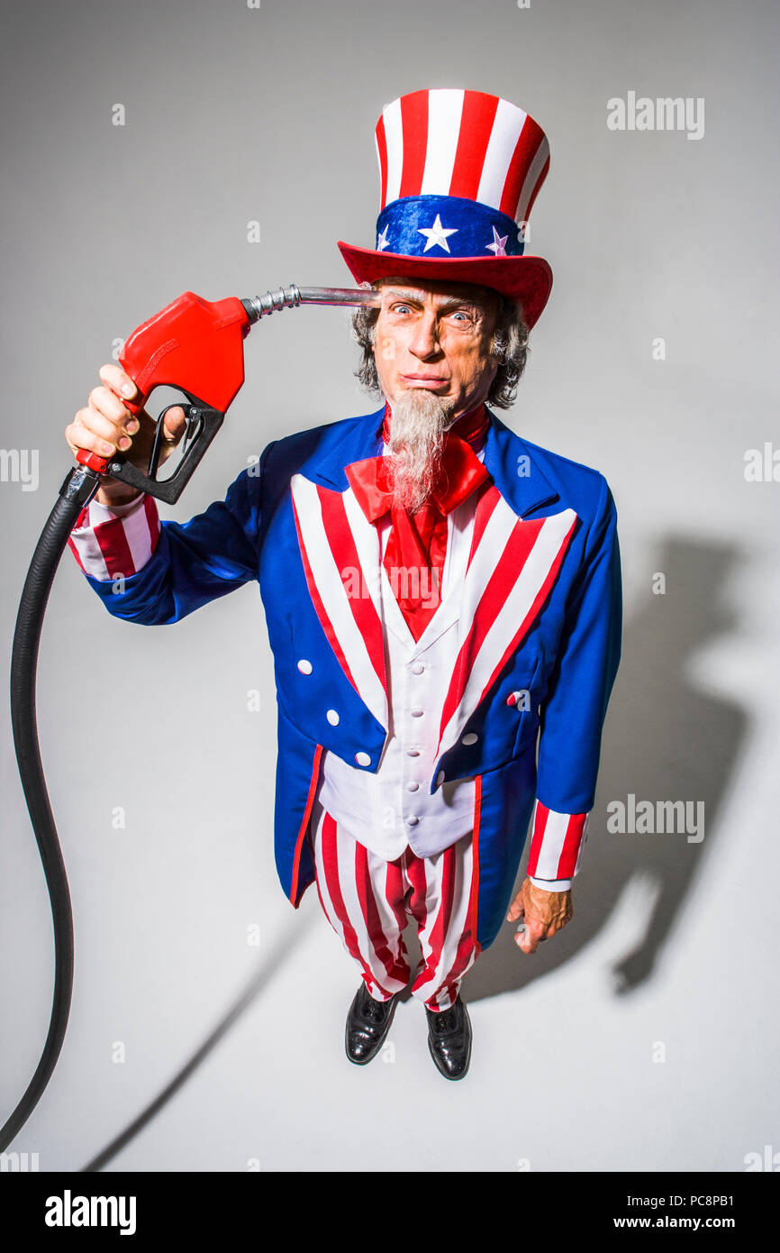 Uncle Sam stehend mit einer Gaspumpe nozzel vor ihm statt. Konzeptionelle Schuß mit der Darstellung der Amerikanischen Abhängigkeit vom Öl/Gas/Öl. Stockfoto