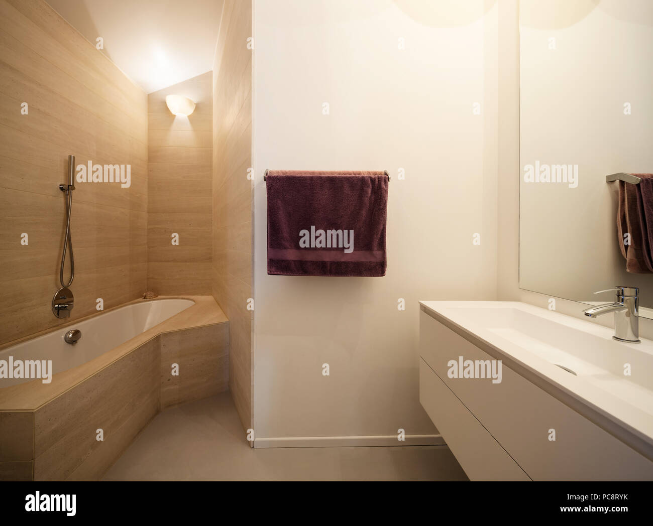Modernes Bad, Waschbecken und Badewanne mit Marmor Fliesen an den Wänden Stockfoto