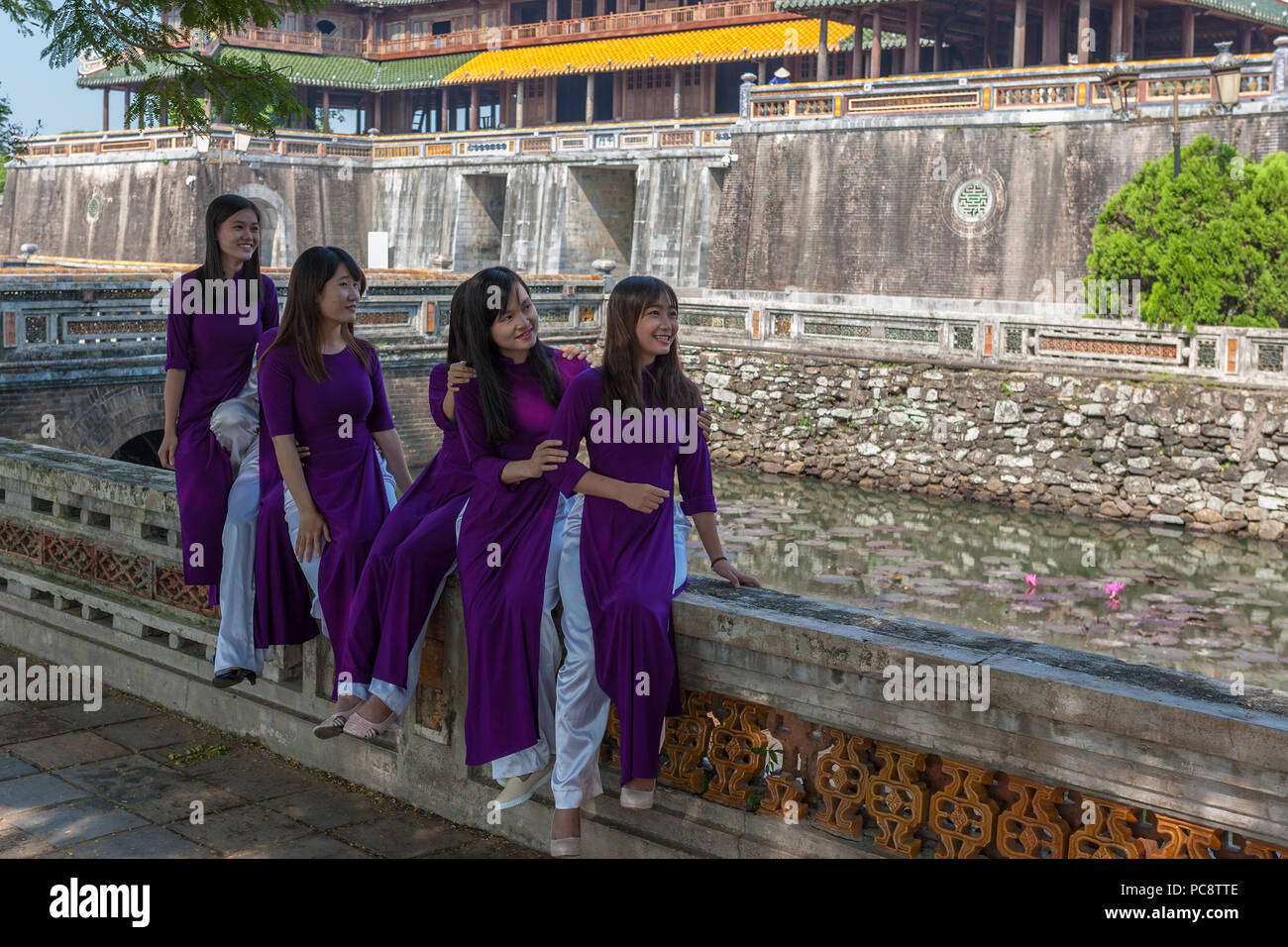 Studenten, die traditionelle 'áo dài' außerhalb des Ngọ Môn Tor der Kaiserstadt, Hue, Vietnam Stockfoto