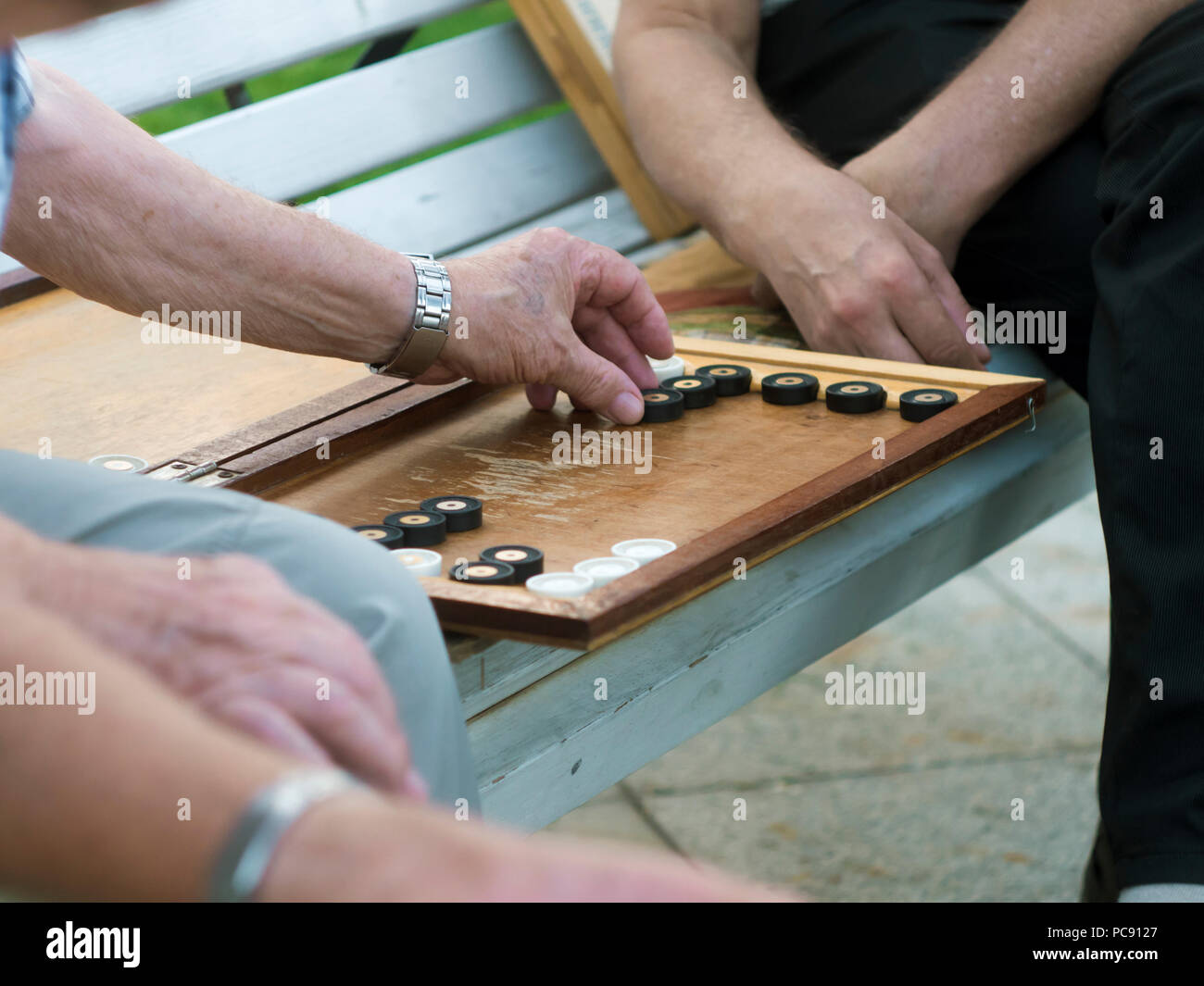 Zwei ältere Männer Backgammon spielen auf der Bank in der Straße in der Nähe von Stockfoto