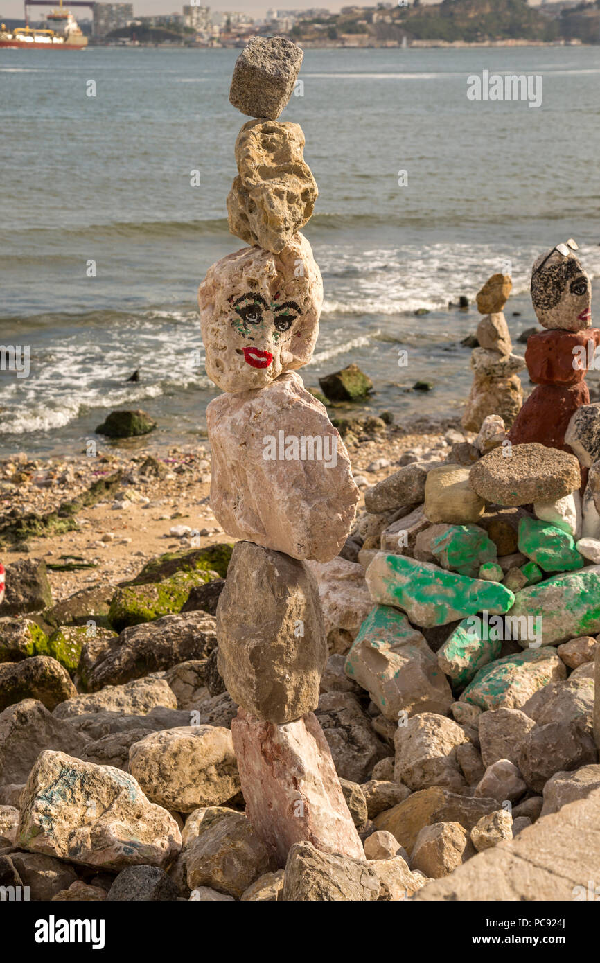 Gestapelte Felsen am Strand in Lissabon, Portugal. Diese Felsen sind auch eingerichtet und haben Gesichter gemalt. Stockfoto
