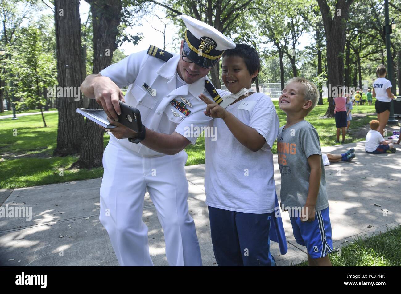 180724-N-VH 385-0167 FARGO, N.D. (24. Juli 2018) - Lt Mack Jamieson, ein Eingeborener von Fulton, Fräulein der Marine von Community Outreach zugeordnet, nimmt eine selfie mit Kindern des YMCA und lokalen Jungen und Mädchen Vereine an Island Park in Fargo, N.D. bei Fargo - Moorhead Metro Marine Woche, 24. Juli 2018. Die Marine von Community Outreach verwendet die Navy Woche Programm Navy Sailors, Ausrüstung mitbringen und zeigt auf etwa 14 amerikanischen Städten jedes Jahr für eine Woche - lange Zeitplan von outreach Engagements für Amerikaner ausgelegt aus erster Hand zu erfahren, wie die US-Marine ist die Marine der Nation nee Stockfoto