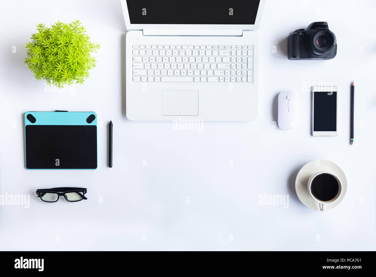 Weiß Schreibtisch im Büro mit Laptops, Smartphones und andere Arbeiten mit einer Tasse Kaffee. Ansicht von oben mit der Kopie Platz für die Eingabe des Textes. Designer Arbeitsbereich Stockfoto