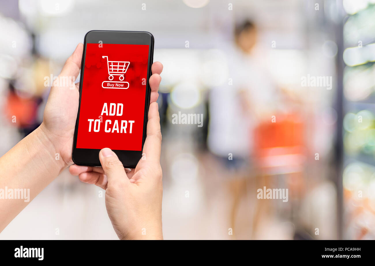 Hand, die mobile In den Warenkorb Produkt hinzufügen online mit Apps Bildschirm blur bokeh Supermarkt Hintergrund zu kaufen, online shopping Konzept, digitale lifes Stockfoto