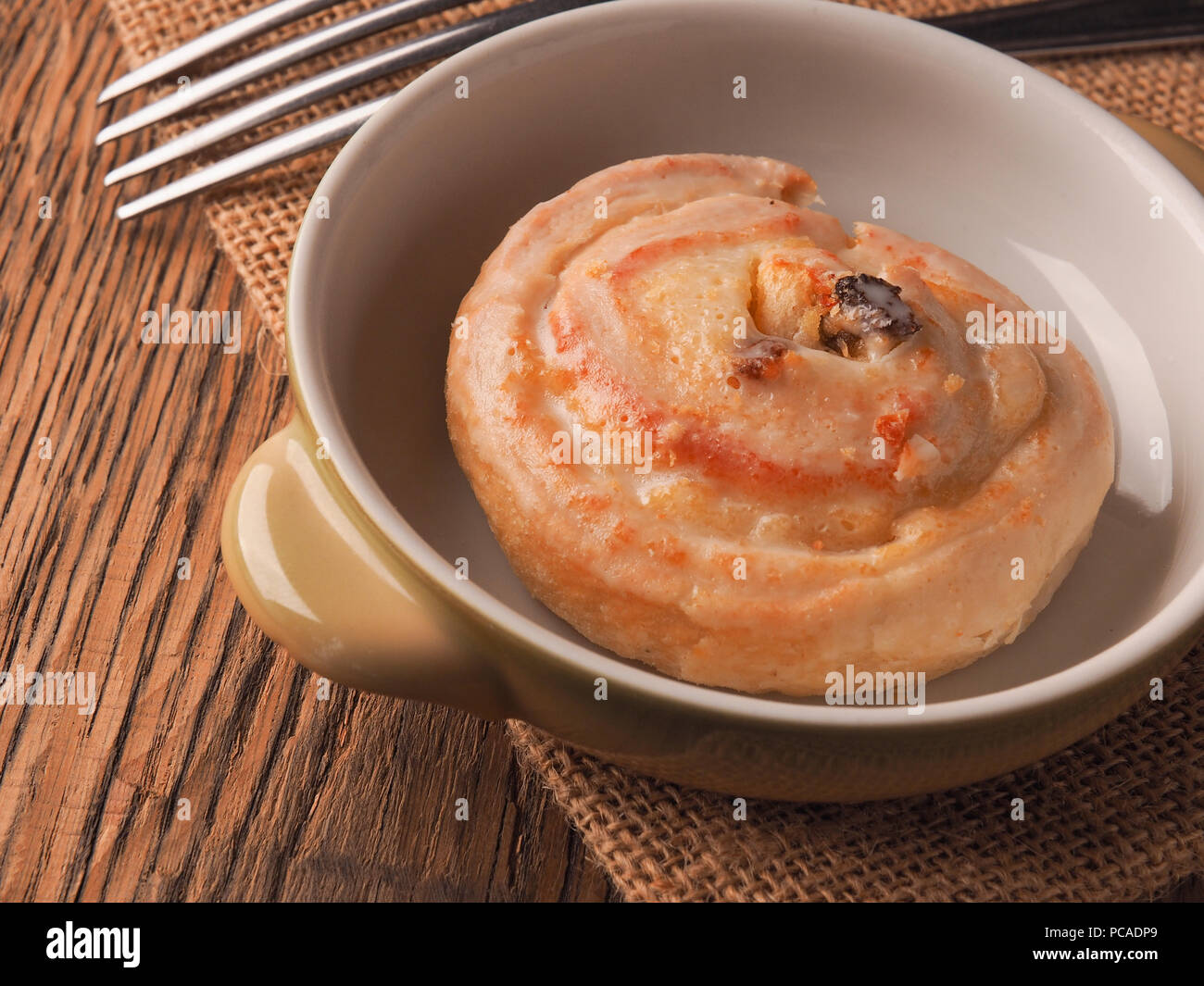 Leckere raisin Schnecke in der Nähe auf einem rustikalen Holztisch, süße Speisen Konzept Stockfoto