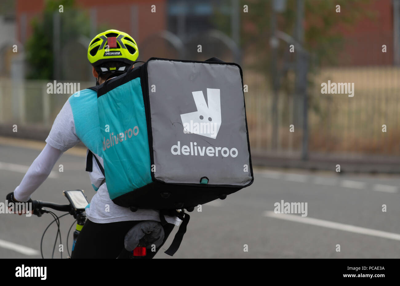 Eine Deliveroo fast food Anlieferung Treiber auf einem Fahrrad in Cardiff, Wales, UK gesehen. Stockfoto
