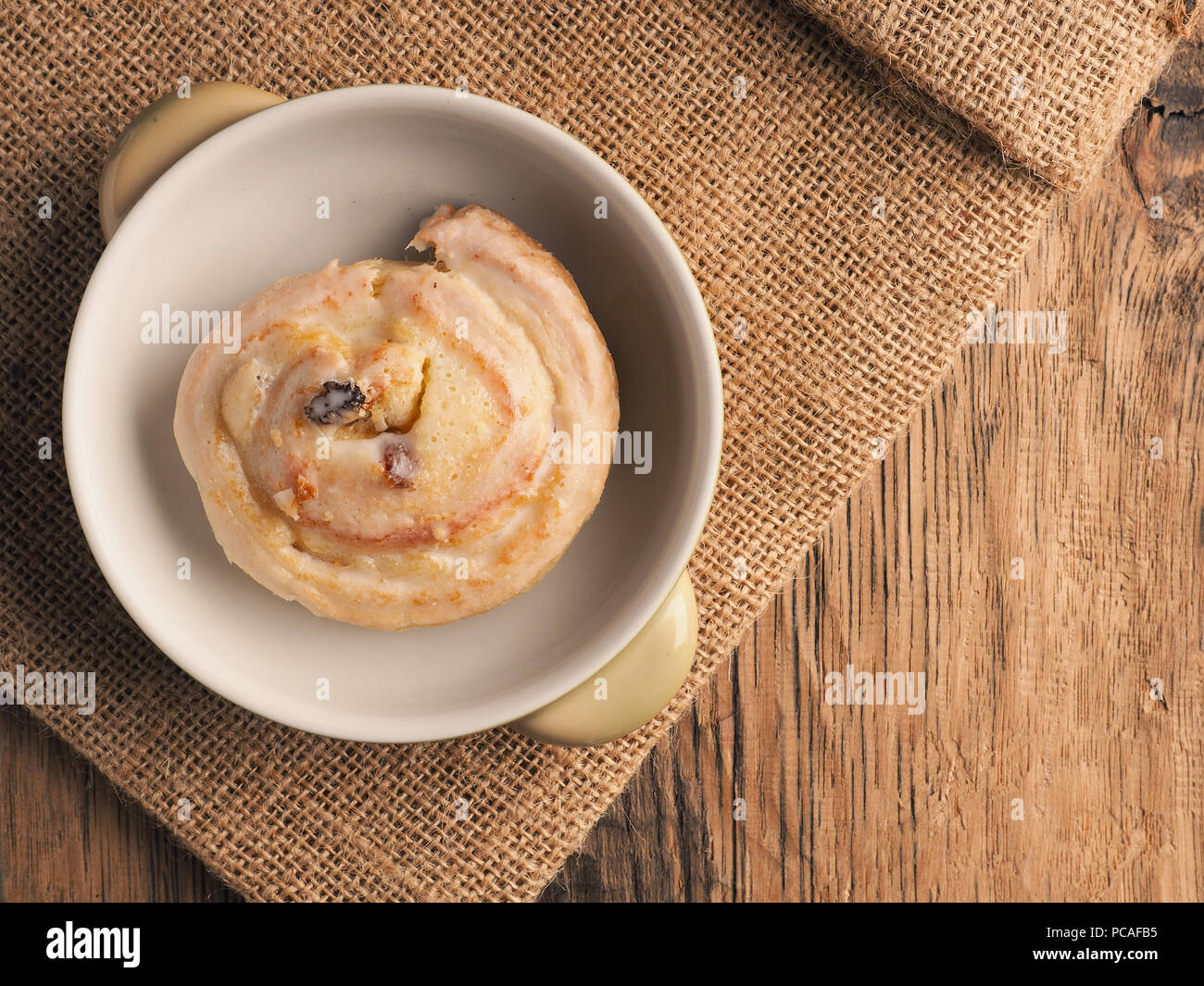Leckere raisin Schnecke in der Nähe auf einem rustikalen Holztisch, süße Speisen Konzept, Ansicht von oben Stockfoto