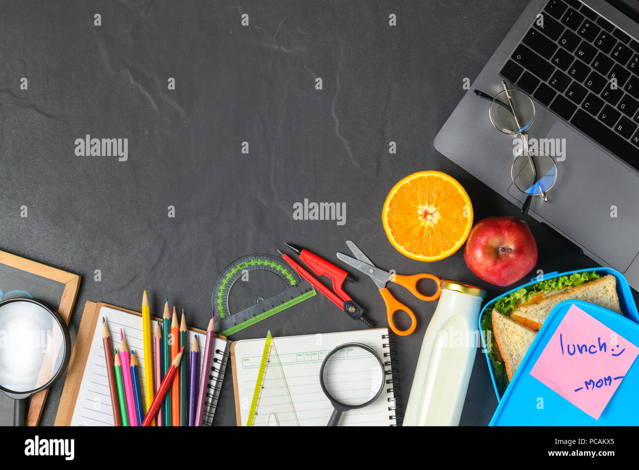 School Lunch Box und Obst für Kinder mit Rucksack und Schulmaterial, zurück in die Schule Konzept Stockfoto