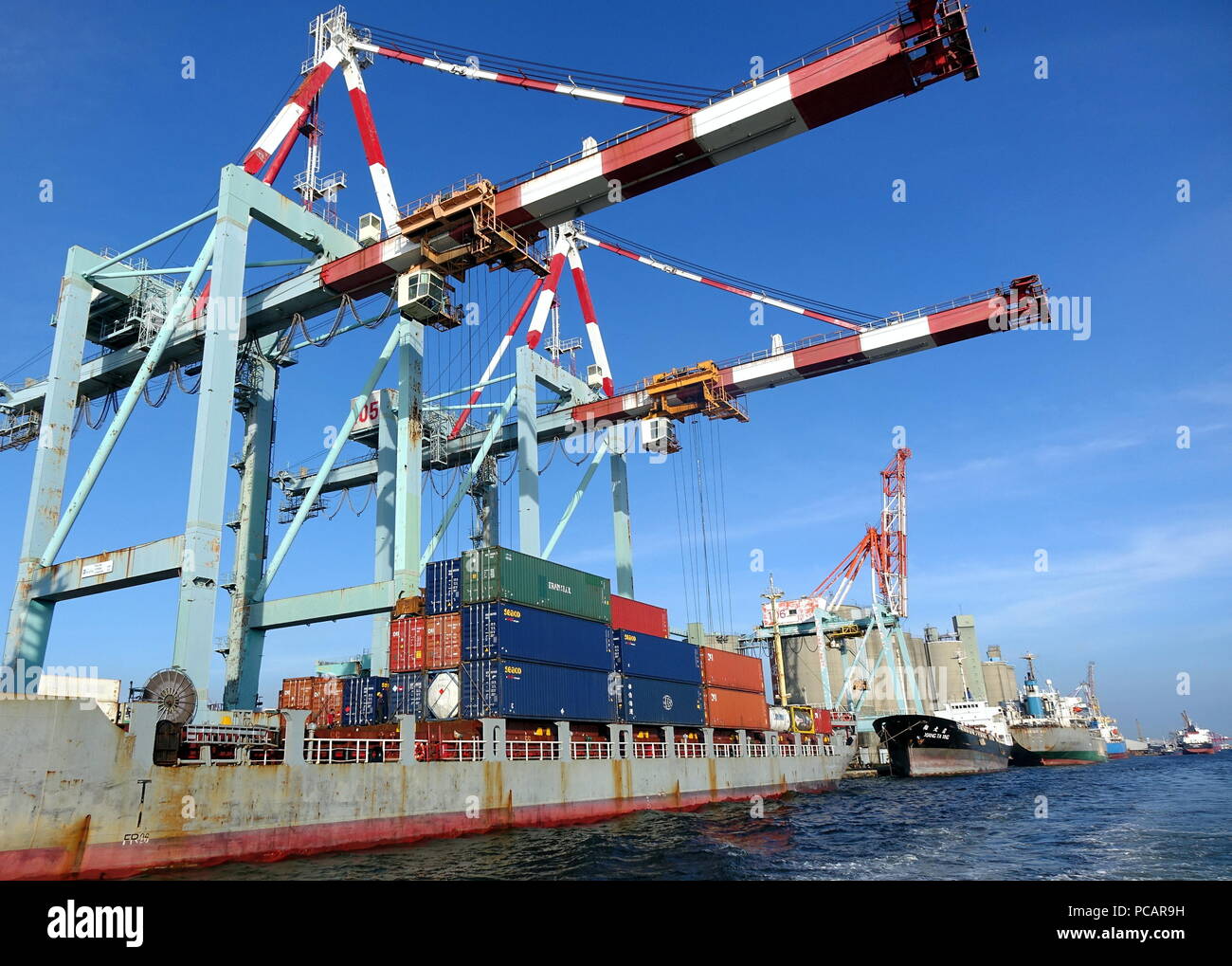 KAOHSIUNG, TAIWAN - 26. MAI 2018: Die Container werden in der geschäftigen Hafenstadt Kaohsiung, einem wichtigen Handelszentrum für Taiwan geladen. Stockfoto