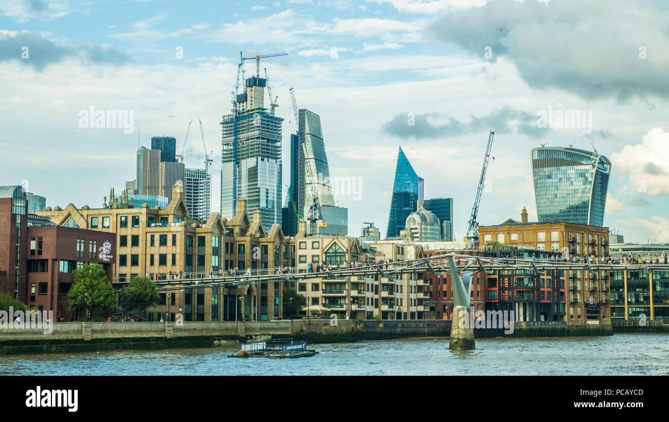 Millenium Bridge (Fußgängerbrücke) über die Themse mit dem 'Cheesegrater' & 'Walkie-Talkie' (rechts) Wolkenkratzer. Stockfoto