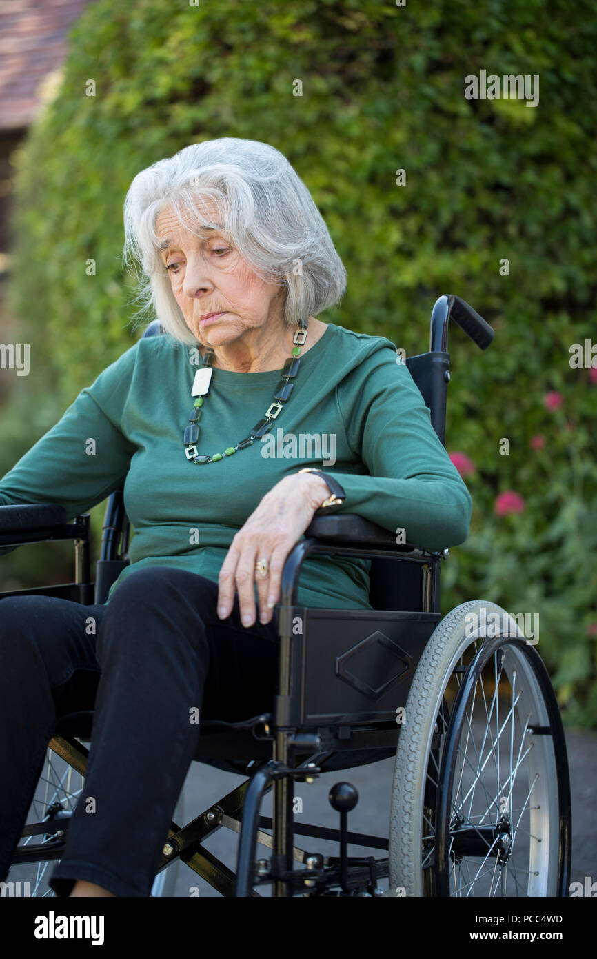 Deprimiert ältere Frau im Rollstuhl sitzen im Freien Stockfoto