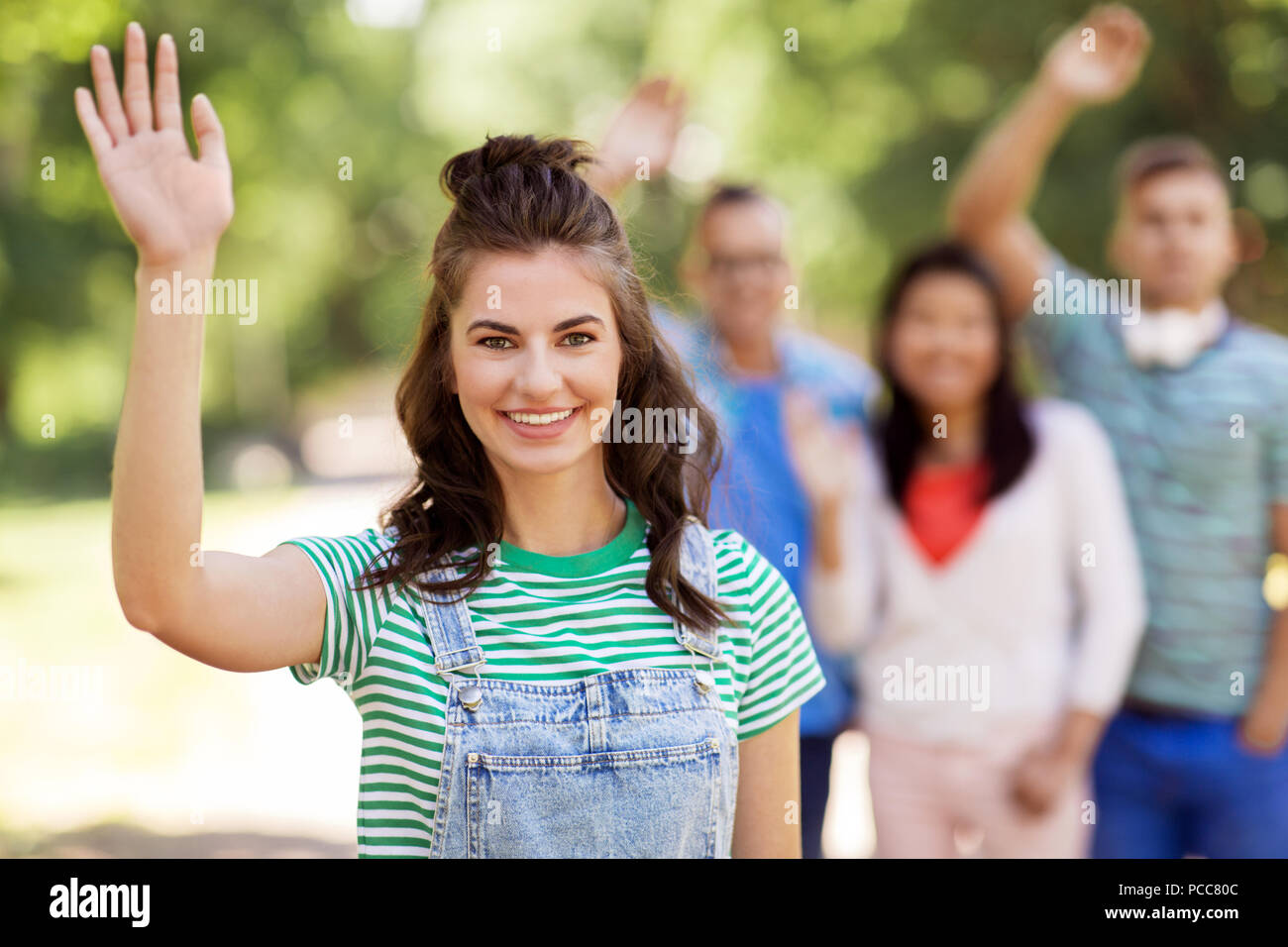 Gruppe von Happy internationale Freunde winkende Hände Stockfoto