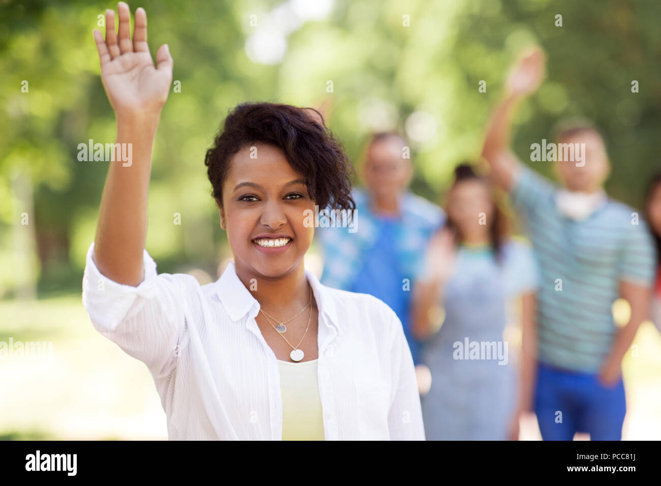 Gruppe von Happy internationale Freunde winkende Hände Stockfoto