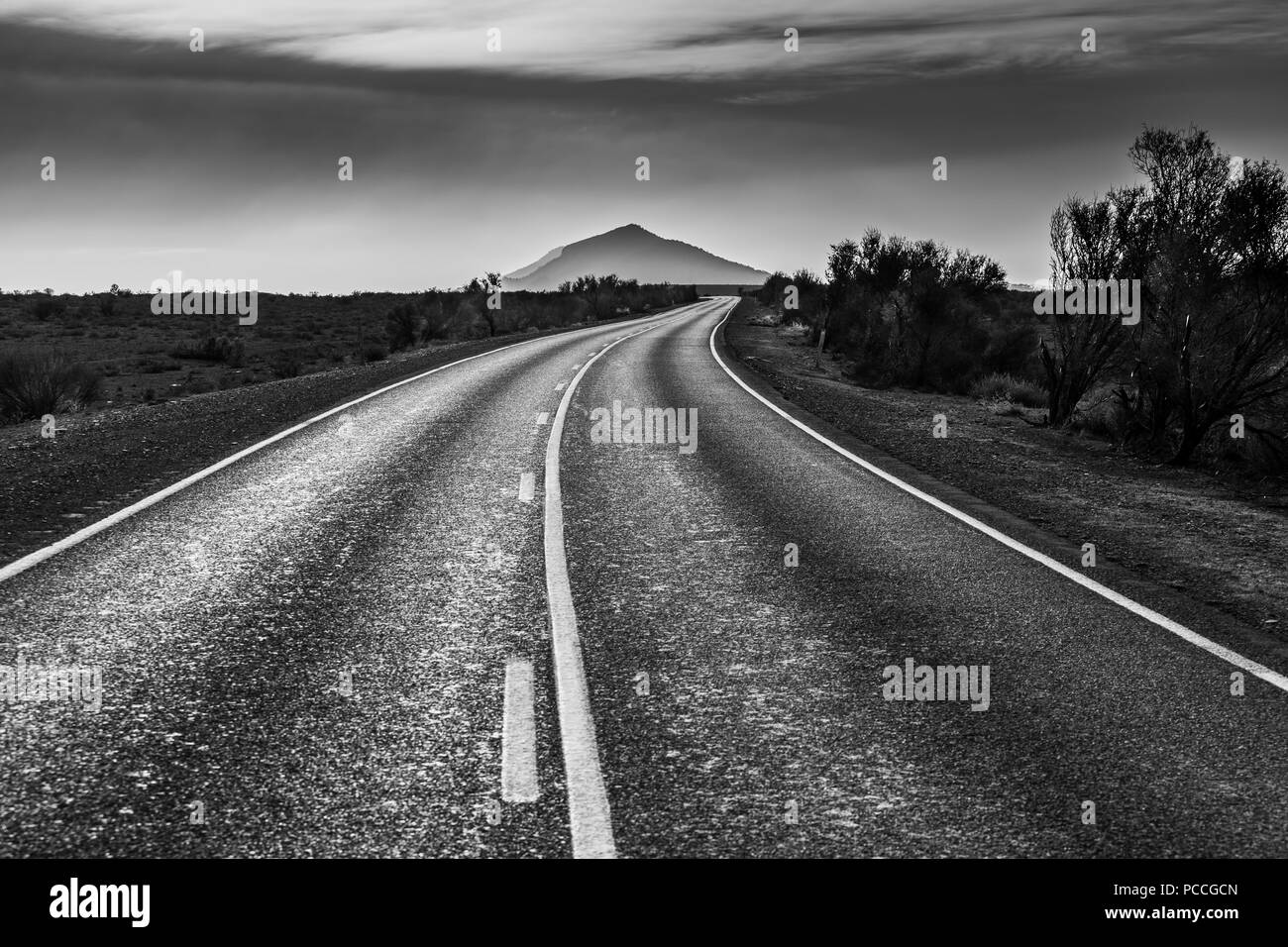 Die ländlichen Straßen in South Australian Outback, die zu einem wunderschönen Berg in Schwarz und Weiß Stockfoto