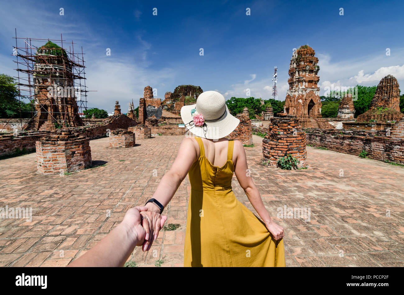Porträt der schönen Asiatin führt Ihr Partner von Hand zu den berühmten Wat Mahathat. Der Wat ist ein buddhistischer Tempel in Ayutthaya, Thailand. Stockfoto
