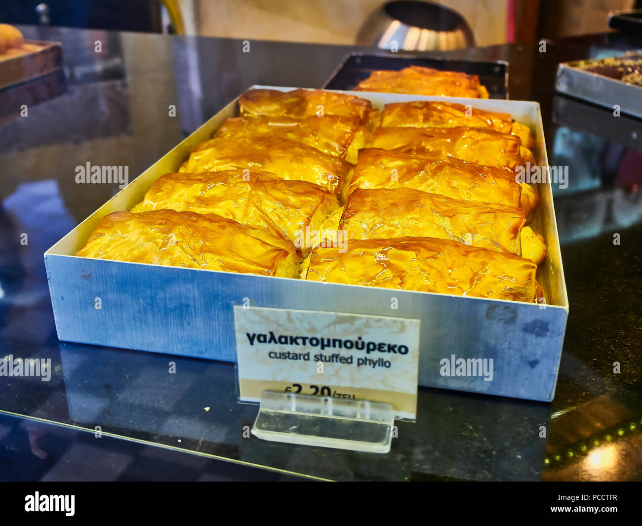 Galaktoboureko, typisch griechischen Süß in einem Schaufenster eines Griechischen Gebäck. Pudding gefüllte griescreme. Stockfoto