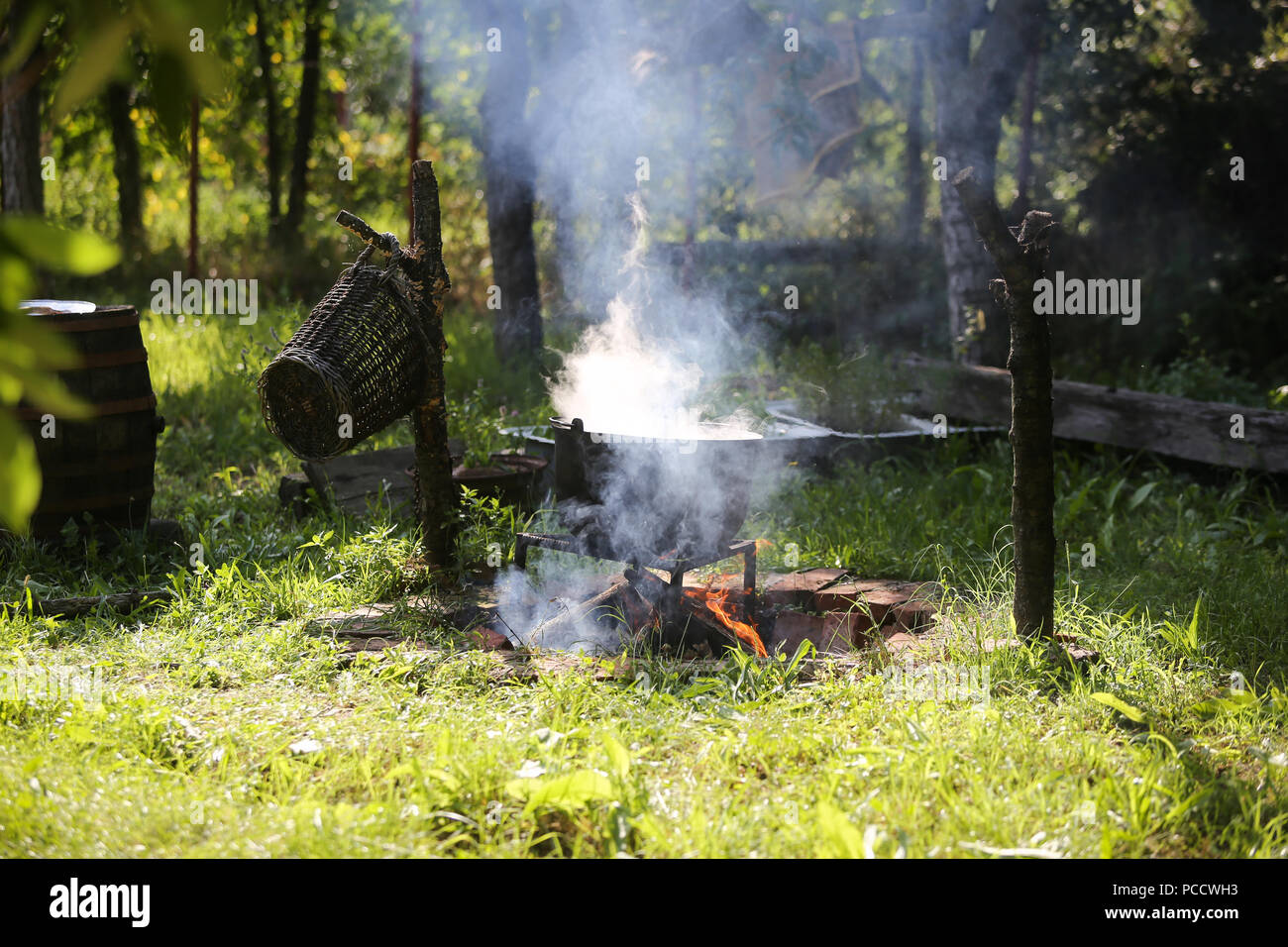 Gusseisen Kessel Kochen einer gulasch Eintopf über offenem Holzfeuer im Hinterhof eines ländlichen Haus in Rumänien Stockfoto