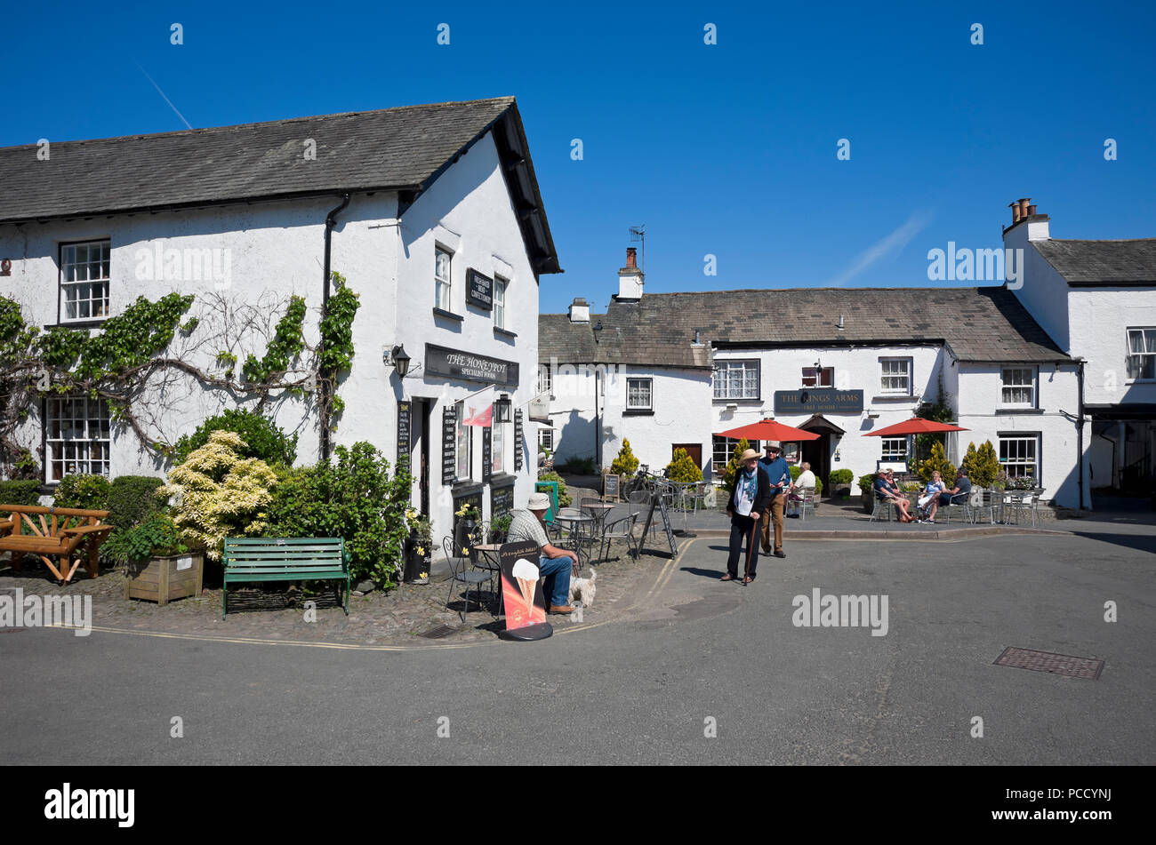 Menschen Touristen Besucher Hawkshead Dorf Straße Pub weiß getünchte Cottages Inn Shop Sommer Lakedistric Cumbria England Großbritannien Großbritannien Großbritannien Stockfoto