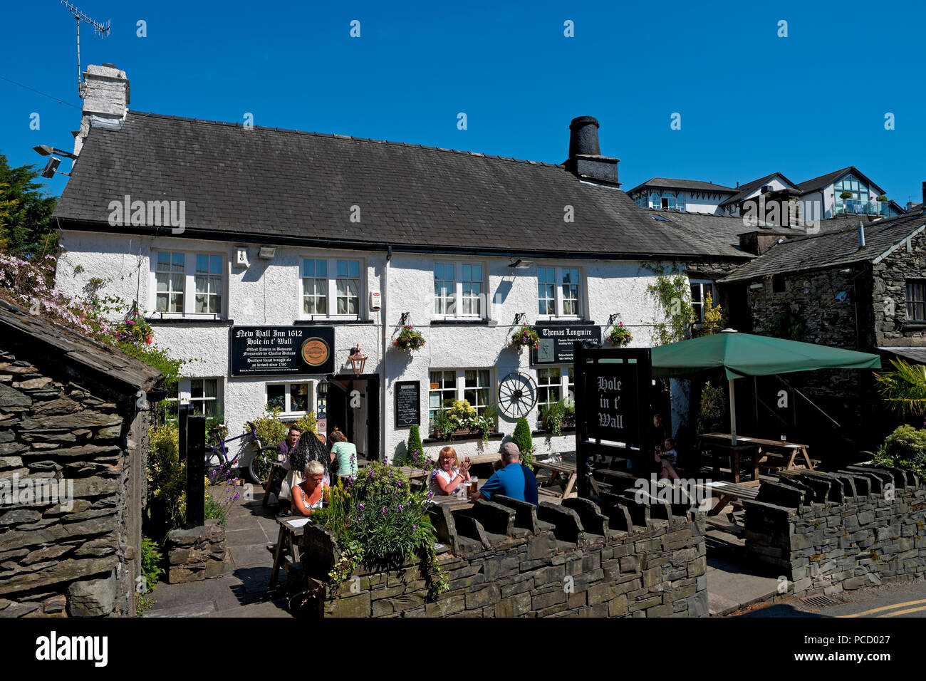 Menschen, die trinken, saßen im Sommer vor dem Hole im Wall Inn Pub Bowness am Windermere Lake District Cumbria England Großbritannien Stockfoto