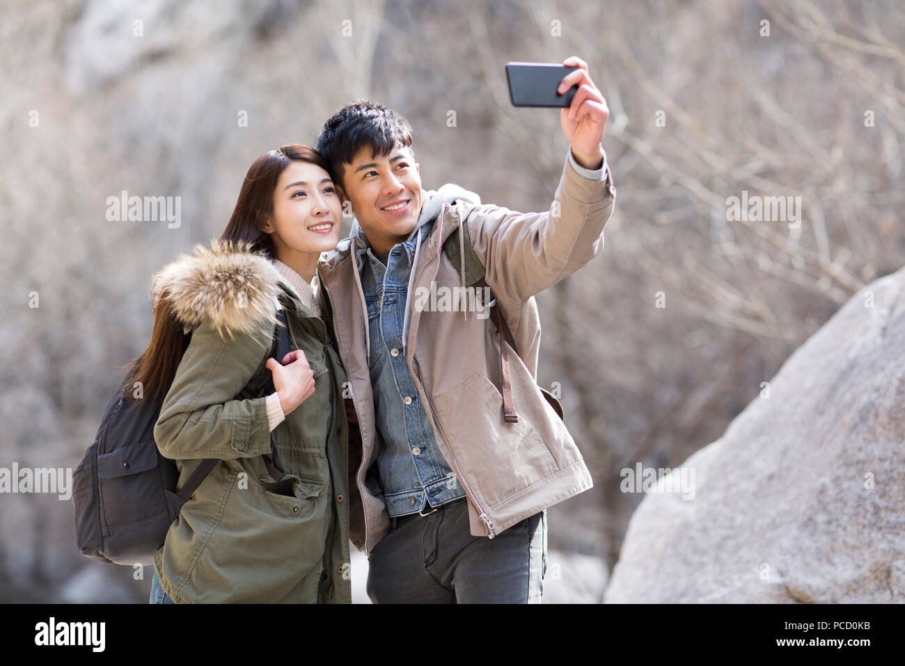 Glückliche junge chinesische Paar unter selfies im Winter Stockfoto