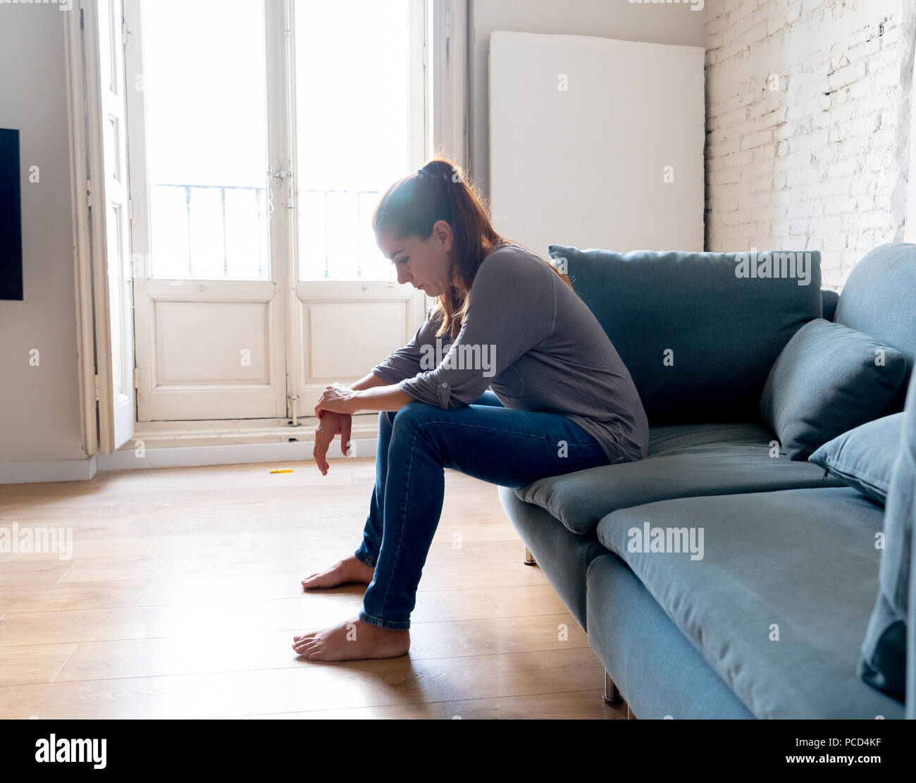 Junge attraktive Latin Frau zu Hause Wohnzimmer Couch liegend traurig müde und Sorgen leiden Depressionen in der psychischen Gesundheit, Probleme und gebrochen Stockfoto