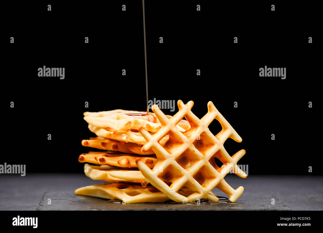 Foto von Wiener Wafer mit Honig auf einem schwarzen Hintergrund Stockfoto