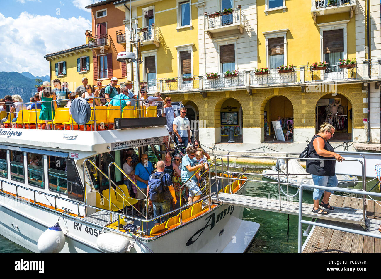 Passagiere verlassen ein kleines Boot in Malcesine am Gardasee. Stockfoto