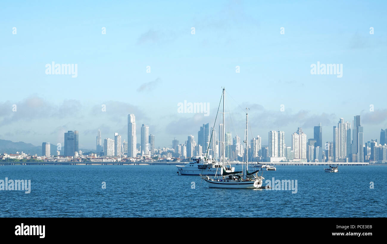 Mehrere Boote in der Nähe von Amador Causeway verankert mit der ständig wachsenden Stadt von Panama im Hintergrund Stockfoto