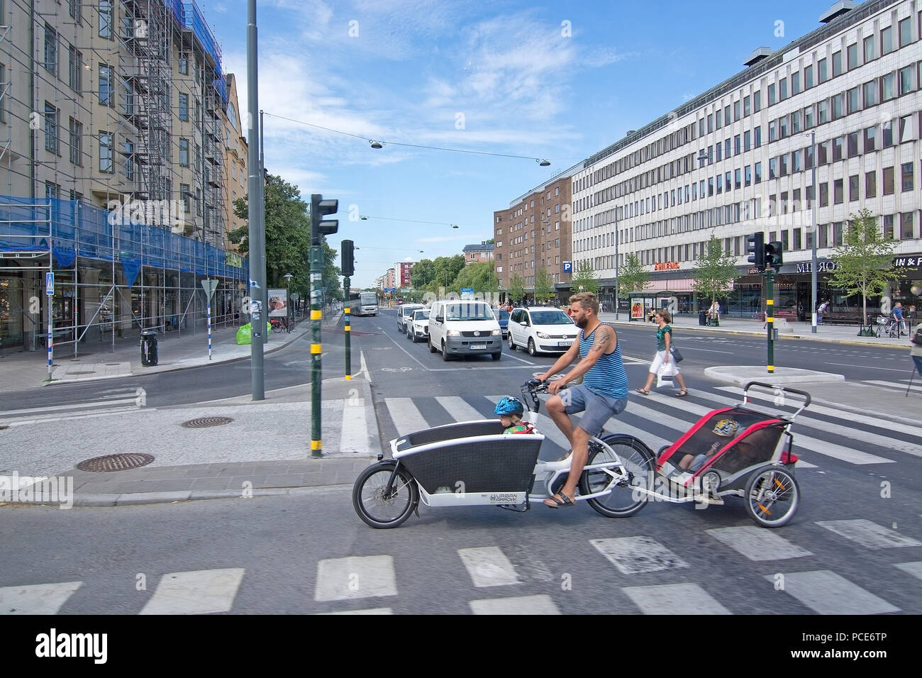 STOCKHOLM, Schweden - 11. JULI 2018: Radfahrer mit Kind wagen Kreuze Fridhemsplan am 11. Juli 2018 in Stockholm, Schweden. Stockfoto