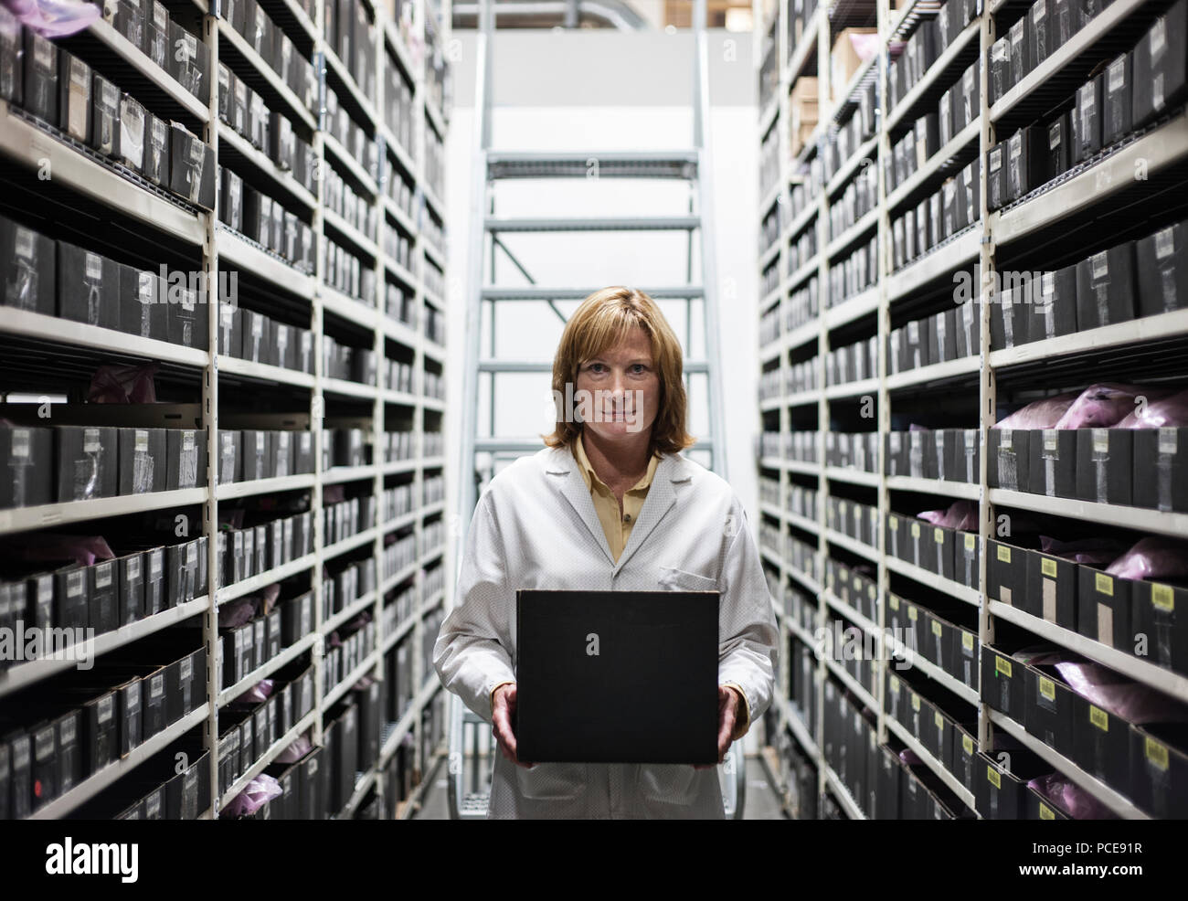 Ein kaukasischer weiblichen techinician arbeitet an einem Laptop Combuter im Gang der Teile in einem technischen Forschung und Entwicklung. Stockfoto