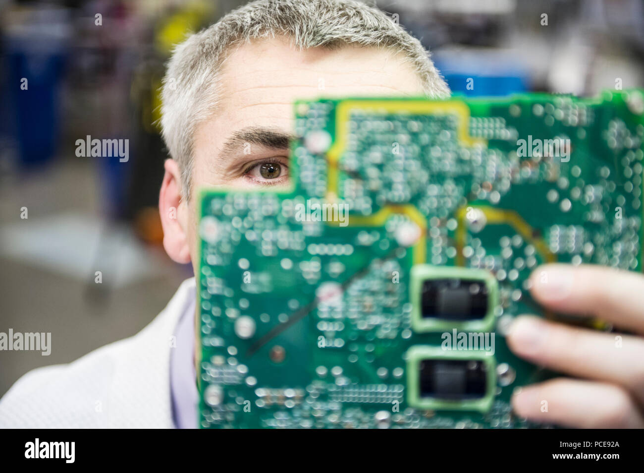 Ein Kaukasier Männlich Techniker examinging eine Platine in der technischen Forschung und Entwicklung. Stockfoto
