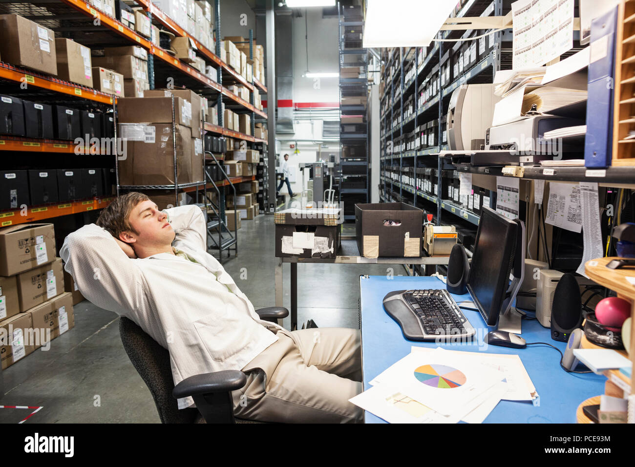 Ein männlicher Techniker entspannend an seinem Schreibtisch im Ltzr in der technischen Forschung und Entwicklung. Stockfoto