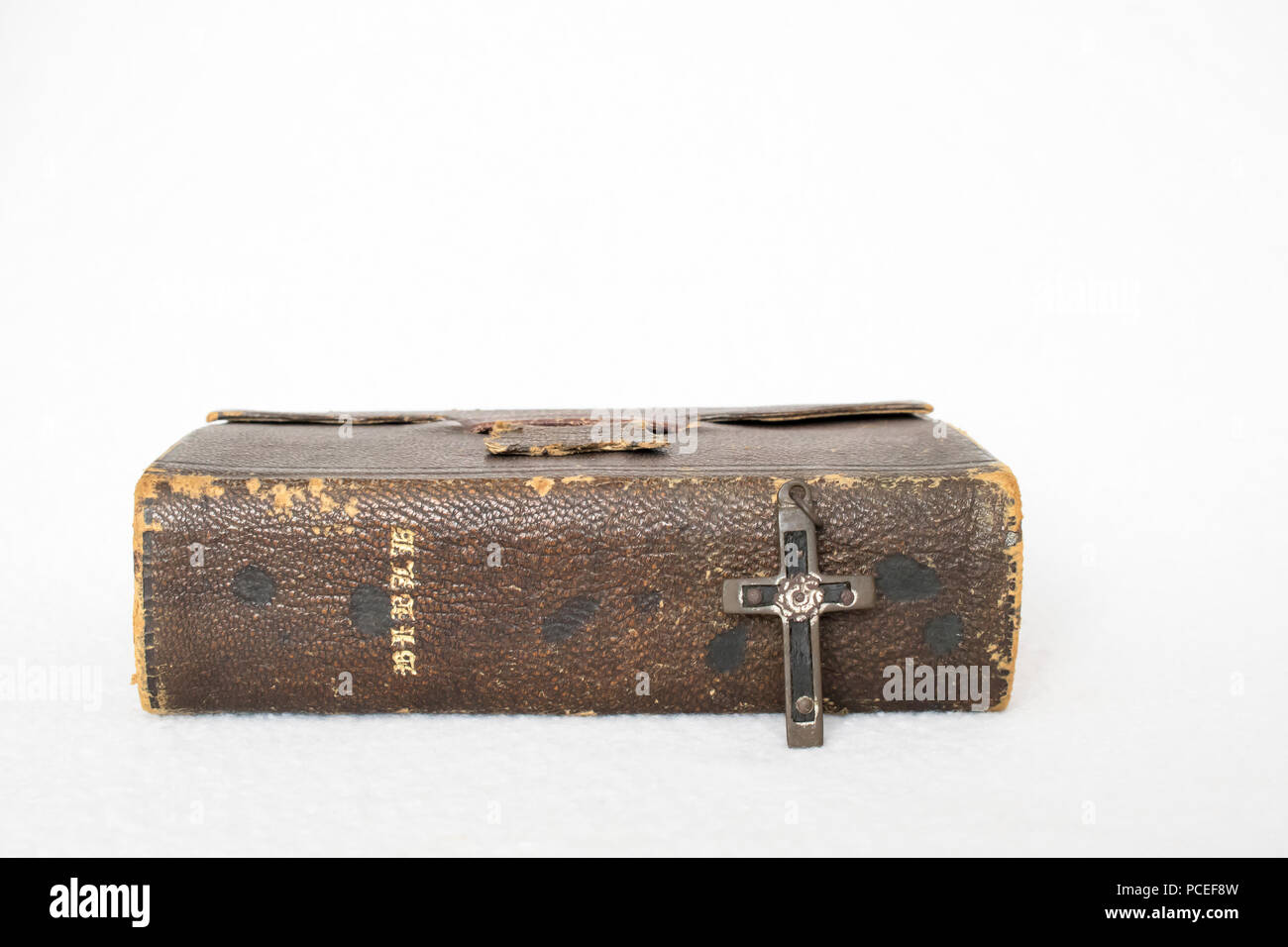 Antike Bibel mit antiken Kreuz auf weißem Hintergrund Stockfoto