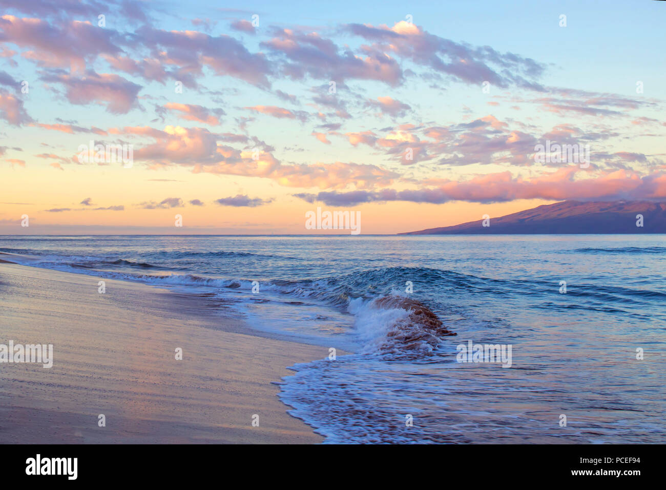 Sonnenaufgang am Strand mit bunten Wolken und Meer Stockfoto