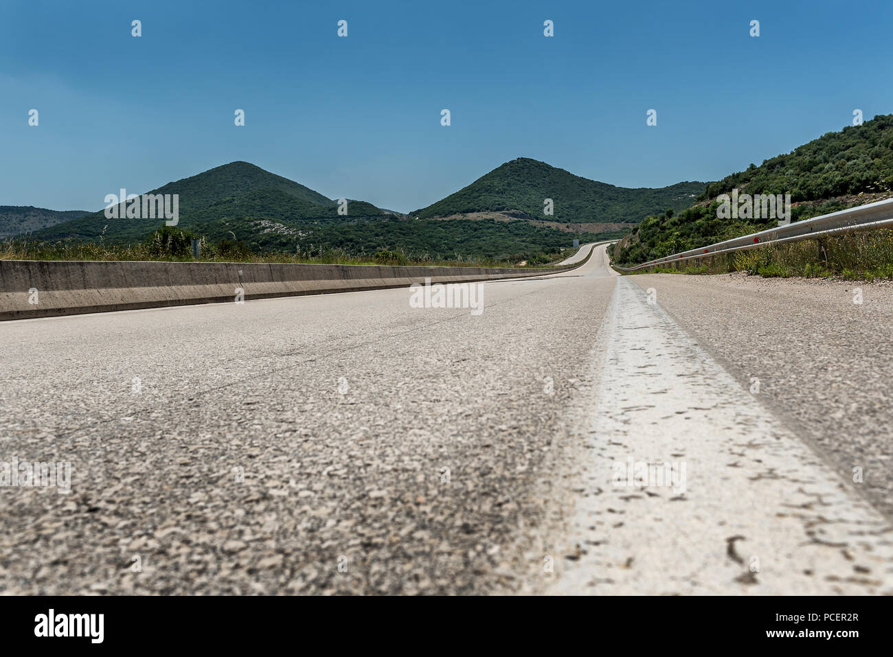 Autobahn oder Landstraße Wicklung zwischen Hügeln in einer ländlichen Landschaft Stockfoto