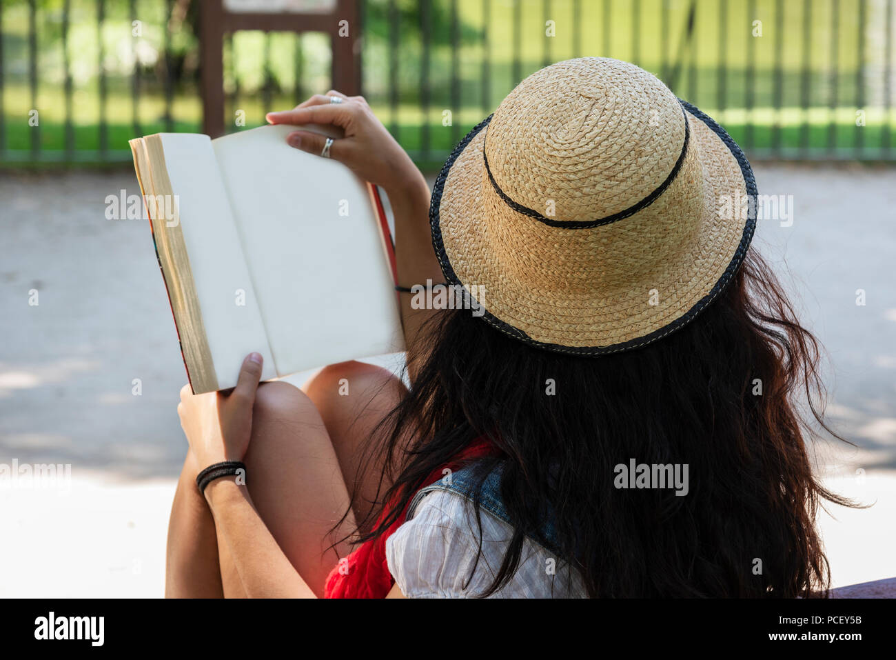 Eautiful junge Dame ein Buch lesen, sitzen auf einer Bank im Park. Entspannt Konzept Stockfoto