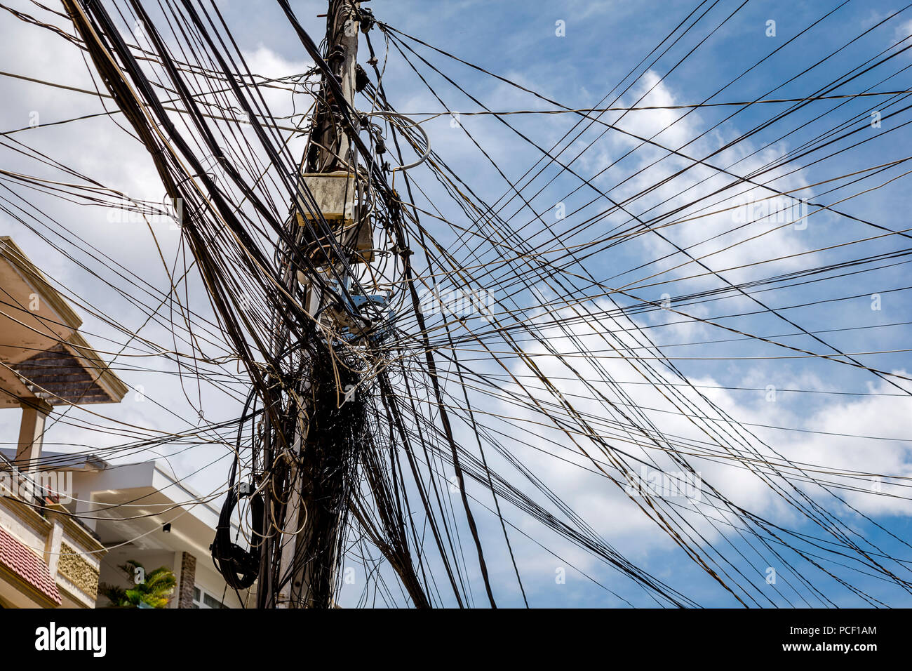 Hohe Drähte eine grafische Muster und Telefonmasten, mit blauem Himmel und Wolken Stockfoto