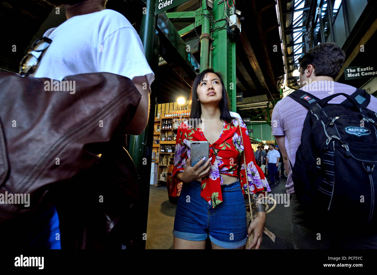 Asiatische Tourist in einem überfüllten Borough Markt, Southwark, London, England, UK. Stockfoto