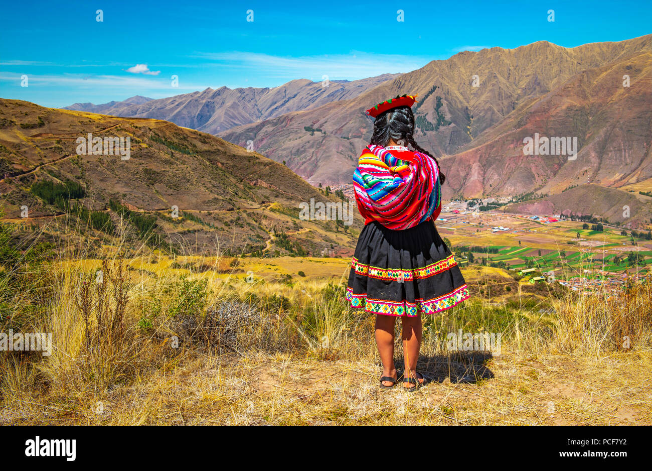 Indigenen Quechua Dame in traditioneller Kleidung (Rock, Hut und Textil) und Frisur im Heiligen Tal der Inka in der Nähe von Cusco, Peru. Stockfoto