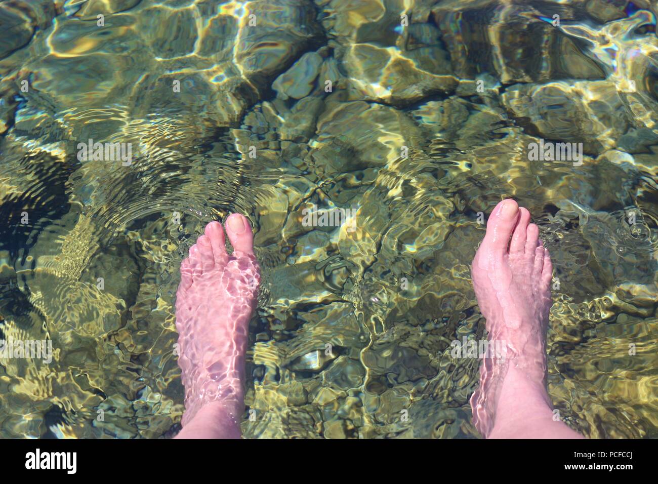 Die Füße ins Wasser zur Erfrischung, in das kristallklare Wasser an der Küste der Adria. Senj, Kroatien, Süd Europa. Stockfoto