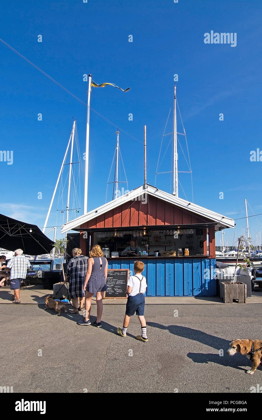 NYNASHAMN, Schweden - 18 Juli, 2018: die Menschen in Nynas Hafen und Marina Restaurants außen am 18. Juli 2018 in Nynashamn, Schweden. Stockfoto