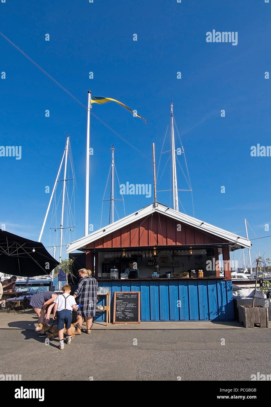 NYNASHAMN, Schweden - 18 Juli, 2018: die Menschen in Nynas Hafen und Marina Restaurants außen am 18. Juli 2018 in Nynashamn, Schweden. Stockfoto