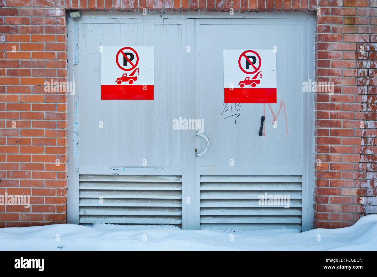 Verschneite Gasse rote Metall Tür Eingang. Stockfoto