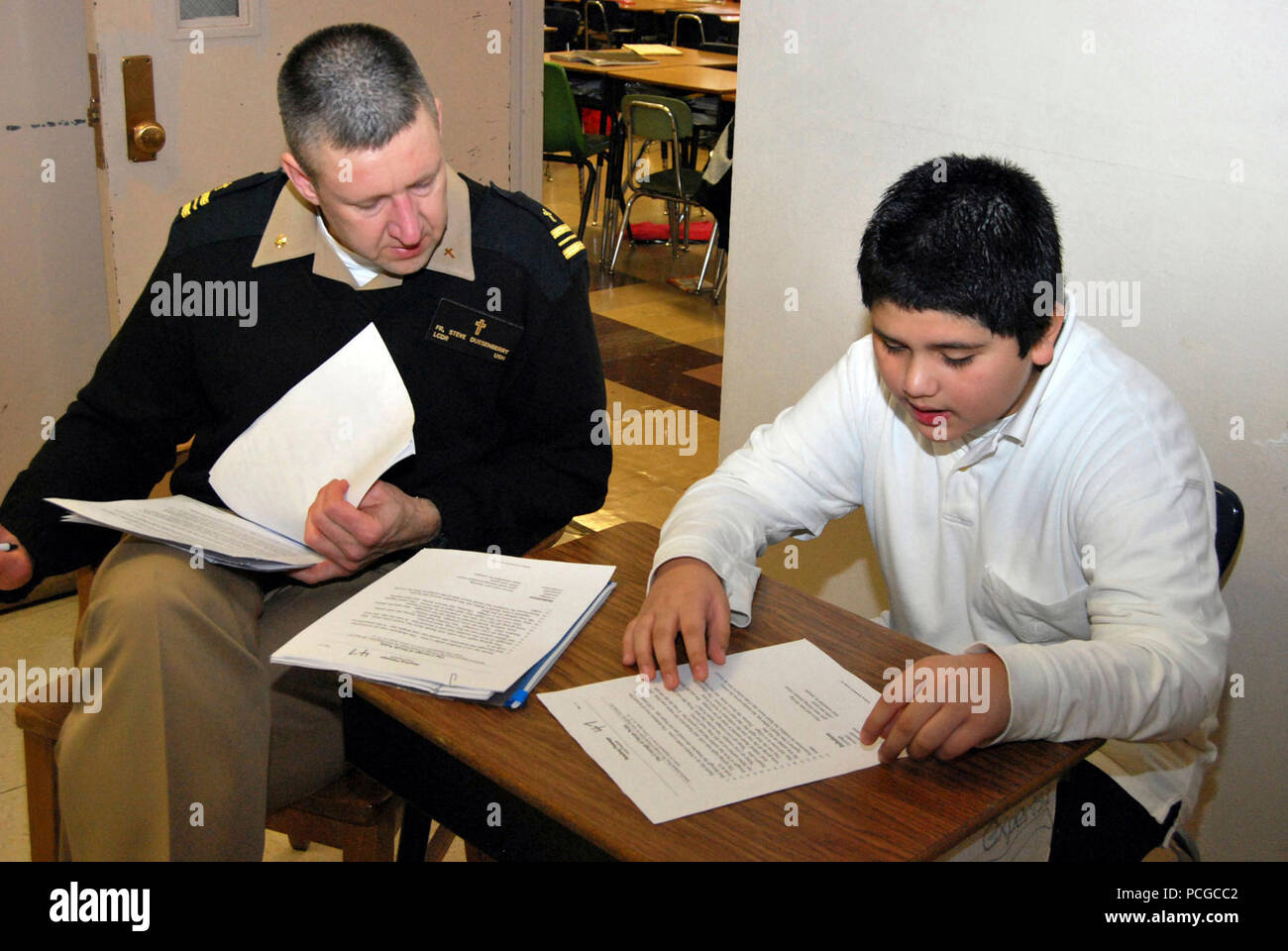 NORTH CHICAGO, Illinois (Feb. 8, 2010) --Lt.Cmdr. Stephen Duesenberry, der kaplan von nur Boot Camp der Marine, Recruit Training Command (RTC) an der Naval Station Great Lakes, Illinois, hört als fünfte - Sortierer Gerardo Rodriguez laut, während eine wöchentliche Nachhilfe Sitzung liest. RTC hat mit Hart-Volksschule in North Chicago, Illinois, für eine Adopt-a-School Lesung Programm gekoppelt. Freiwillige besuchen die Schule jede Woche eins-zu-eins mit den Studenten zu arbeiten, um zu helfen, ihre Lesekompetenz zu verbessern. Stockfoto