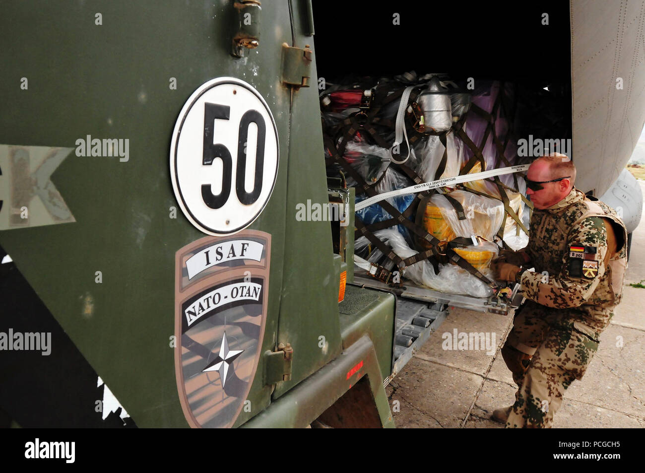 KABUL, Afghanistan - Deutsche Mitglieder der International Security Assistance Force und Flieger von der 438th Air Expeditionary Advisory Group, eine C-27 Spartan Transport Aircraft mit humanitärer Hilfe auf dem internationalen Flughafen von Faizabad, Afghanistan geladen, entladen. Die Beihilfe ist in der südlichen Region von badakhshan am 23. Juni 2010 ausgeliefert werden. (US Navy Stockfoto