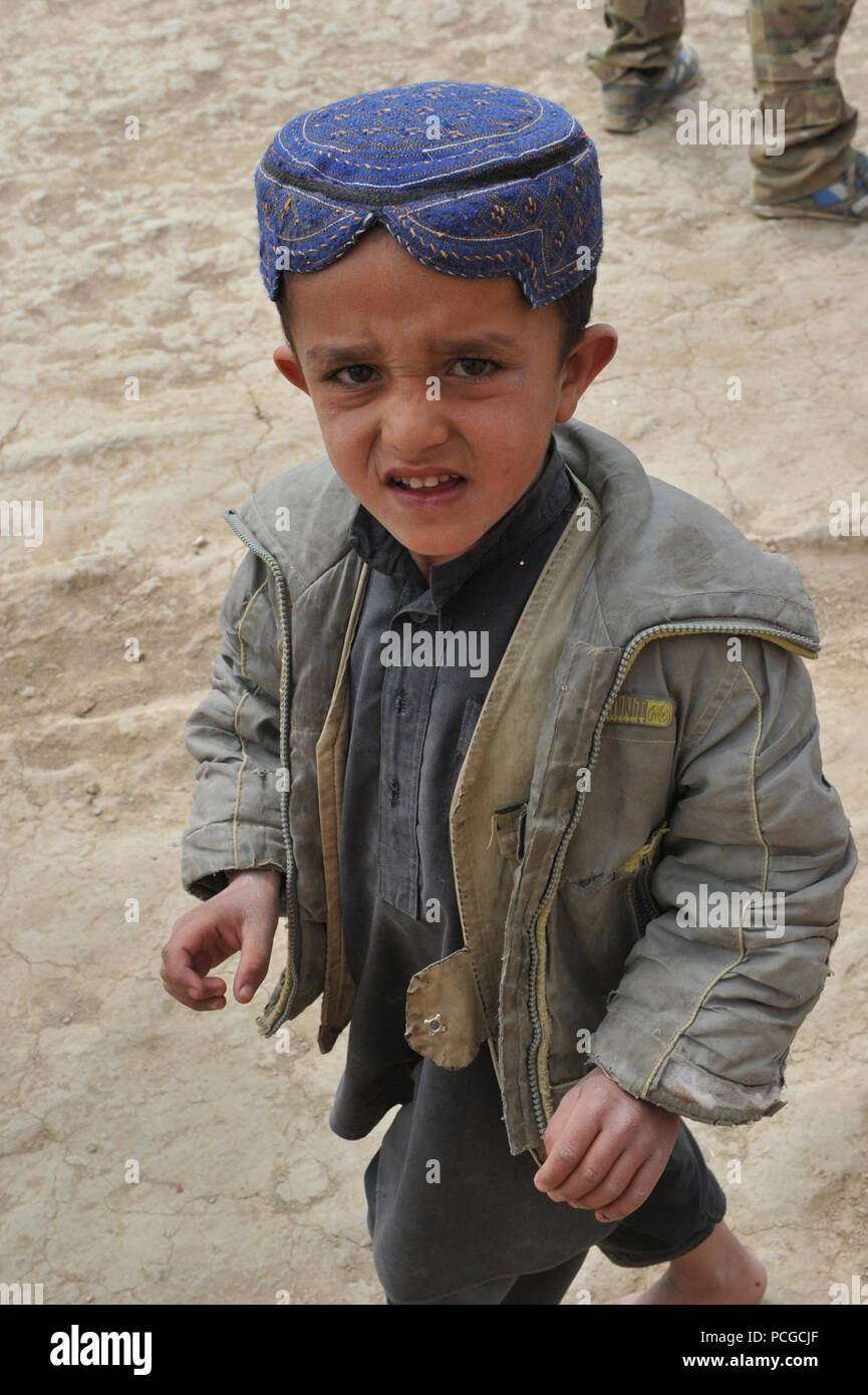 Ein afghanischer Junge Uhren als Koalition Special Operations Forces Soldaten demontiertem Patrouille in Latif Bezirk, Provinz Ghazni, Afghanistan, am 31. März. Demontiert Patrouillen werden verwendet, um lokale Afghanen zu engagieren und eine Beziehung mit führenden Persönlichkeiten im Bereich entwickeln. Stockfoto