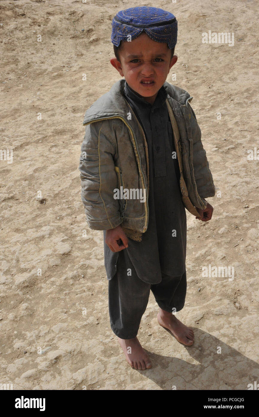 Afghanische junge Uhren als Koalition Special Operations Forces Soldaten demontiertem Patrouille in Latif Bezirk, Provinz Ghazni, Afghanistan, am 31. März. Demontiert Patrouillen werden verwendet, um lokale Afghanen zu engagieren und eine Beziehung mit führenden Persönlichkeiten im Bereich entwickeln. Stockfoto