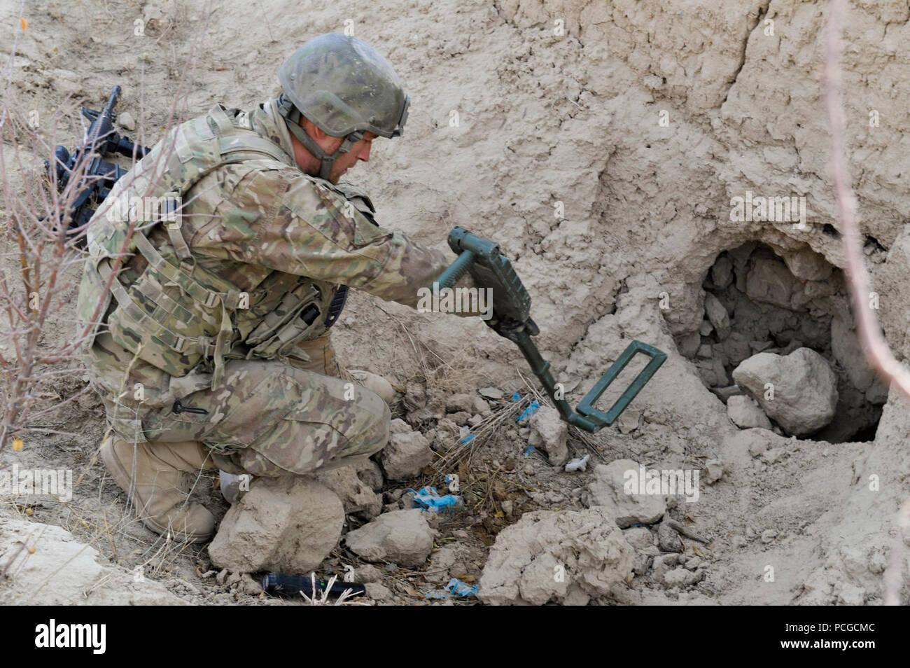Ein Mitglied der Koalition Special Operations Forces verwendet einen Metalldetektor für die Suche nach einem vermuteten Waffen während einer Patrouille führte durch afghanische Polizei in Walan Rabat Dorf, Zabul Province, Afghanistan, Jan. 4 Cache. Stockfoto