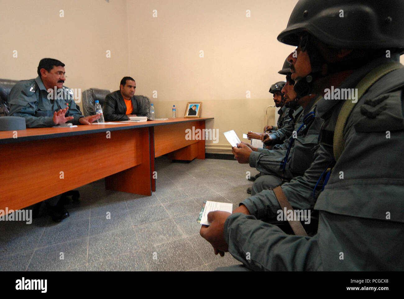 KABUL, Afghanistan (18 April 2010) - Afgahn Col. Khuda yar Toutakhil, Finance Officer, 4. Brigade Afghanischen zivilen Ordnung Polizei (Ancop), ganz links, Slips Mitglieder der Elite Force auf Arbeitsentgelt und Sozialleistungen zu einem Kabul. Die Polizeibeamten registriert und erhalten Einweisungen und Schulungen, da sie für Operationen in Afghanistan vorbereiten. (US Navy Stockfoto